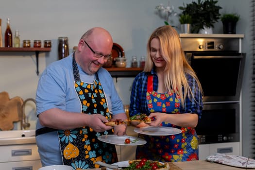 A cheerful duo prepares a delicious meal together, showcasing their teamwork and creativity in the kitchen