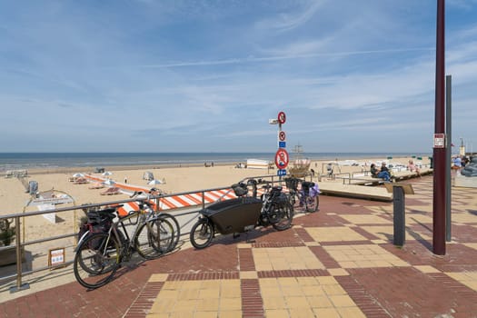 De Haan, Belgium – May 17, 2024: Bicycles on the promenade on the beach at De Haan on the Belgian North Sea