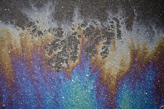 Gasoline rainbow on asphalt creates pollution awareness design