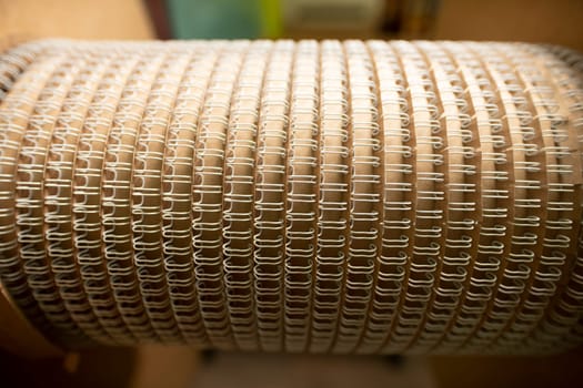 Rounded detail for professional machine tool with identical spirals for paper notebooks in workshop