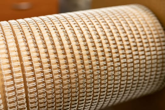Rounded detail for professional machine tool with identical spirals for paper notebooks in workshop