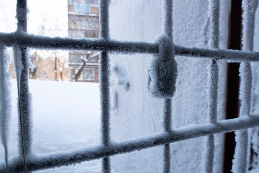 Metal wire door door handle and keyhole are covered with frost - icy lock covered with snowflakes - concept of cold winter