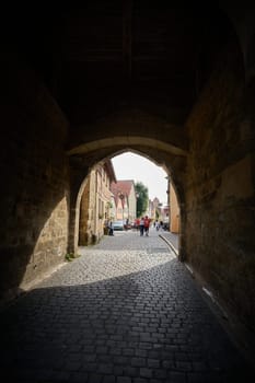 Rothenburg ob der Tauber, Germany – September 22, 2024: View through the archway of the Siebersturm into Spitalgasse in the old town of Rothenburg ob der Tauber in Germany
