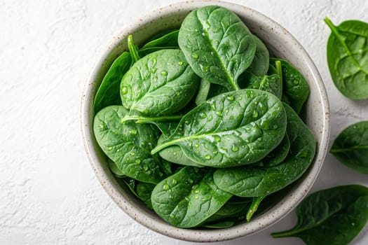 A bowl filled with vibrant green spinach leaves, glistening with water droplets, ideal for fresh salads or cooked dishes.