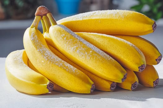 Bright yellow bananas sprinkled with sugar are placed on a counter, illuminated by natural light in a cozy kitchen setting.