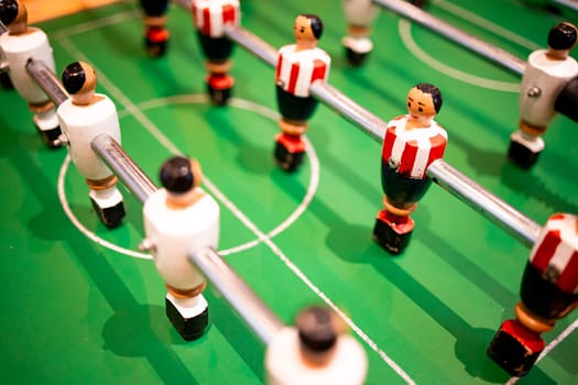 Table soccer game with colorful players on green field.