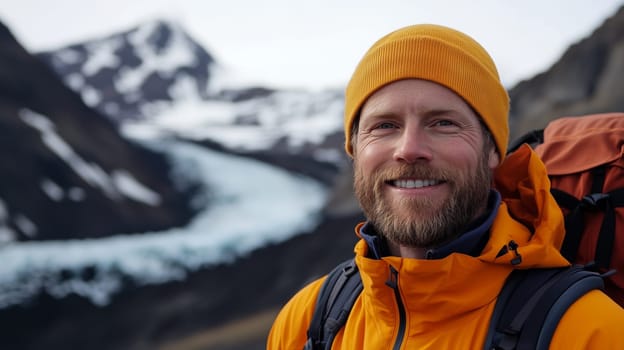 Travel, hiking, adventure, portrait of happy traveler hiker young man in jacket stands on top of snowy mountain looking at camera
