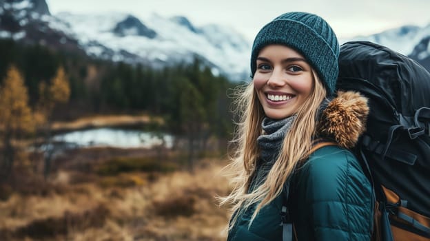 Travel, hiking, adventure, portrait of happy traveler hiker young woman in jacket stands in snowy mountains looking at camera
