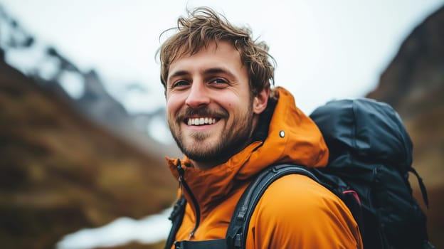 Travel, hiking, adventure, portrait of happy traveler hiker young man in jacket stands on top of snowy mountain looking at camera