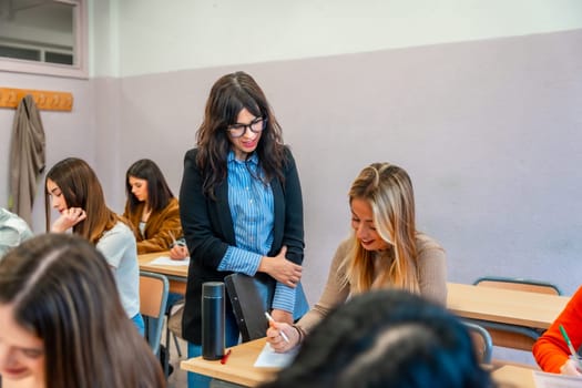 University professor assisting a student during an exam, providing support and guidance in a classroom setting