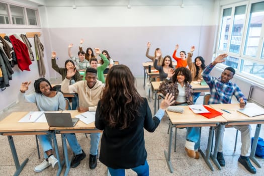 Multi ethnic university students enthusiastically raising hands to respond to the teacher's questions during an engaging classroom lesson
