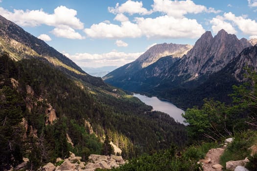 panoramic view of a mountain range with a lake in the valley, the sky is clear and the sun is shining brightly