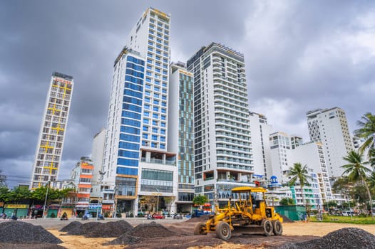A construction site with a bulldozer and heavy machinery at residential skyscrapers in Asia. Nha Trang, Vietnam - December 14, 2024