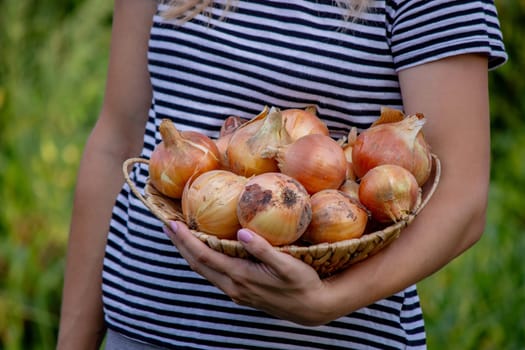 girl holding a bowl of vegetables on a garden background. Selective focus.