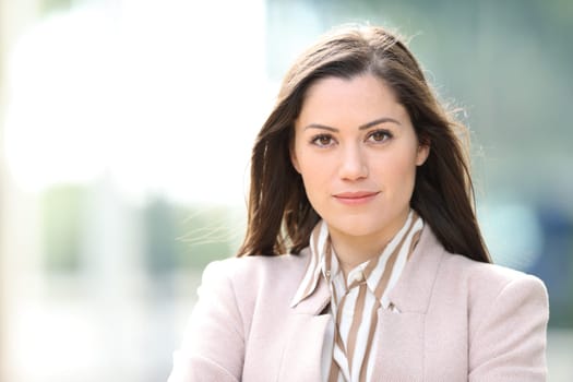 Front view portrait of a serious executive posing standing in the street looking at camera