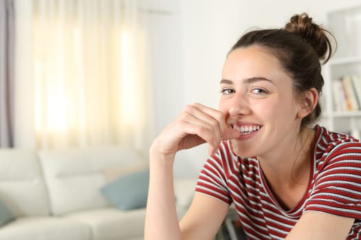 Coquette woman smiling looking at you in the living room at home