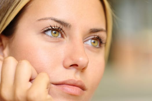 Portrait of the beautiful yellow eyes of a young woman looking away