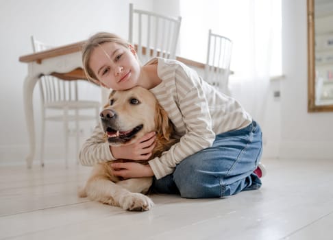 Smiling, A Happy Teenage Girl Hugs And Pets An Adorable Golden Retriever Dog At Home