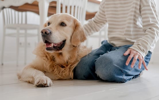 Smiling, A Happy Teenage Girl Hugs And Pets An Adorable Golden Retriever Dog At Home