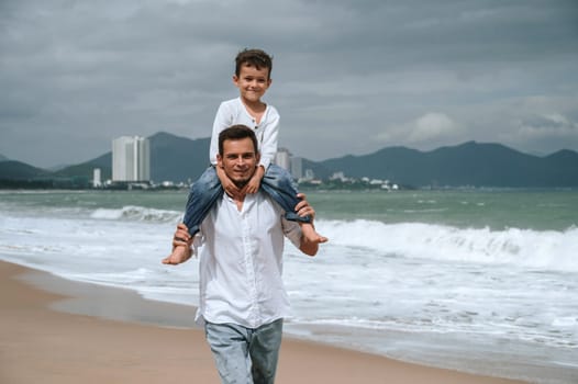 happy father with child son on the beach by the sea in summer on vacation