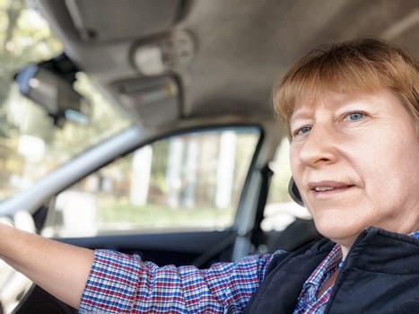 A blonde woman drives her car on an exciting journey, capturing the joy of travel and adventure in her expression.
