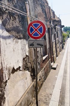 Urban street sign. A no parking and tow-away zone sign on a weathered wall in Catania, Sicily, Italy. The sign indicates strict parking restrictions in the area.