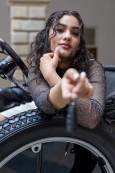 Attractive young woman is sitting in a vintage car and handing the keys of  a modern car. Focused on her face.