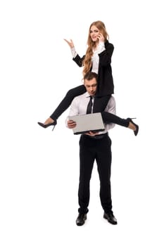 Full body of female manager discussing business issues during phone call while sitting on shoulders of male colleague using laptop as concept of business cooperation and support
