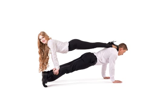 Side view of male manager in formal wear lifting cheerful female colleague against white background