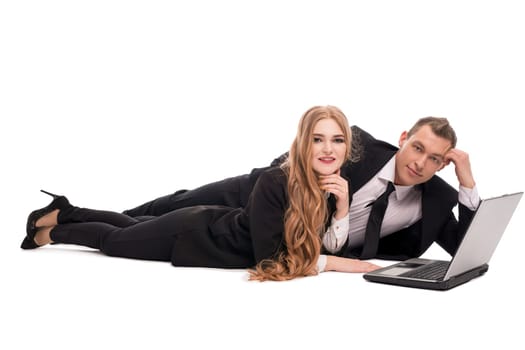 Excited businesswoman in suit looking at camera while lying near colleague against white background