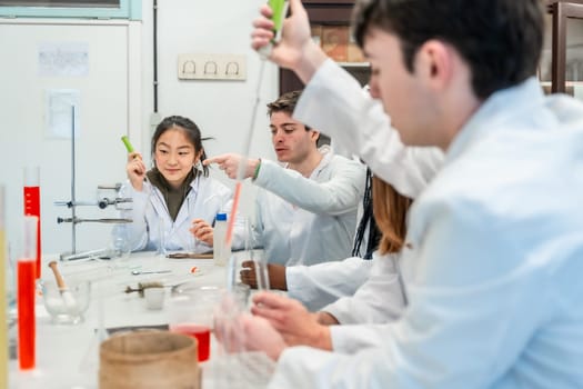 University students in lab coats conducting a chemistry experiment, collaborating and learning together