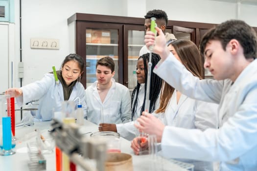 University students in lab coats conducting a chemistry experiment using colorful liquids and lab equipment
