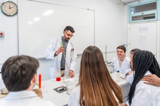 Chemistry teacher performing a titration experiment for a multi ethnic group of students in a university laboratory