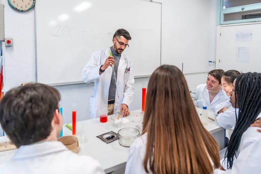 Chemistry teacher performing a chemical experiment with students in a university laboratory, using lab coats and equipment