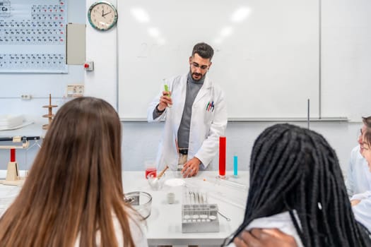 University teacher wearing lab coat performing a chemistry experiment with colorful liquids in beakers and test tubes, in front of multi ethnic students