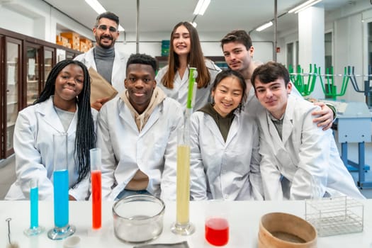 Group of diverse university students and their teacher posing together in a chemistry laboratory, showcasing teamwork and scientific exploration