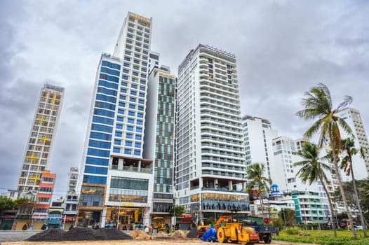 A construction site with heavy machinery at residential skyscrapers in Asia. Nha Trang, Vietnam - December 14, 2024