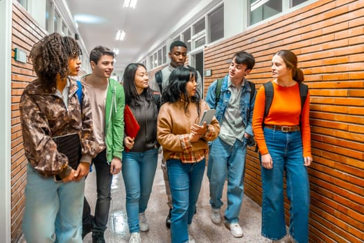 Group of diverse university students walking down school hallway, discussing and collaborating on their way to class