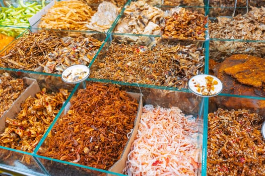 assortment of dried fish and seafood for snacks on the counter at Asian fish market in Vietnam
