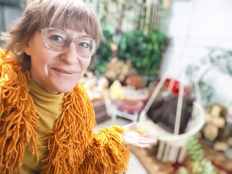 Smiling blonde woman in glasses shares travel adventures and lifestyle tips in a cozy indoor setting.
