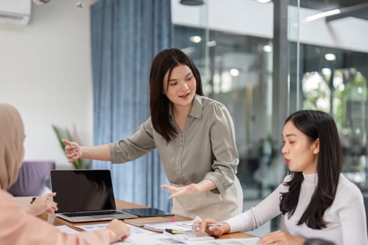 A group of professional women collaborates in a meeting, discussing budget and financial strategies with charts and documents.