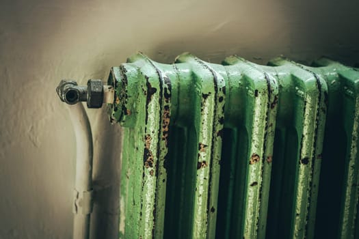 This image showcases a vintage green radiator with a rustic patina, set against a simple background, evoking feelings of nostalgia and the passage of time.