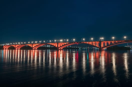 Night view of the famous Communal bridge in Krasnoyarsk through the Yenisei River in Russia, Krasnoyarsk. This bridge is depicted on the 100 rouble bill