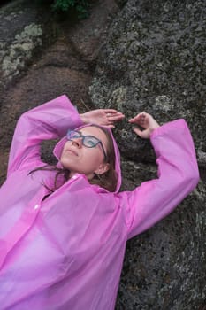 Portrait of woman in the raincoat the taiga forest and rocks of the Stolby nature reserve park, Krasnoyarsk, Russia