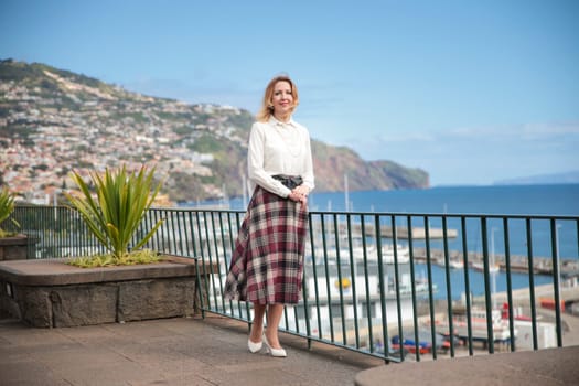 Businesswoman standing on a terrace overlooking funchal harbor in madeira island, portugal