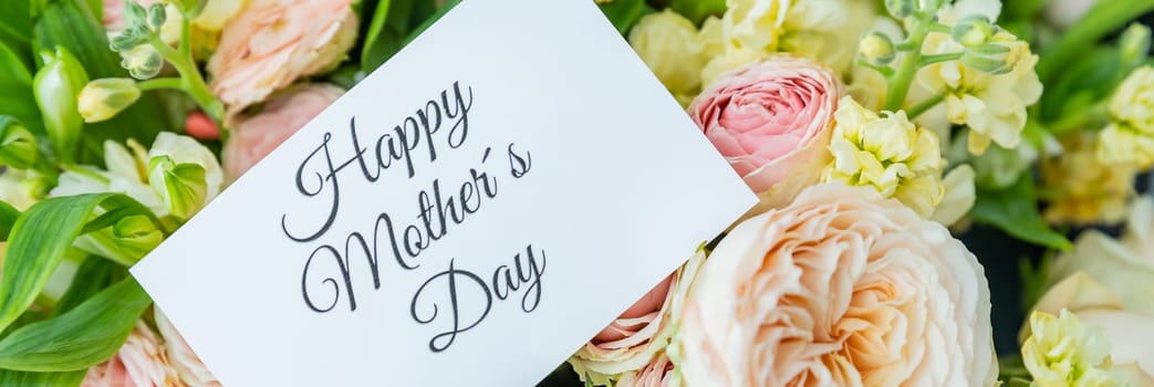 Amazing tender bouquet with pink ranunculus, violet Alstroemeria flowers and tiny white roses in cardboard box with pink ribbon. Beautiful bunch of spring flowers. Easter gift. Seasonal spring flowers