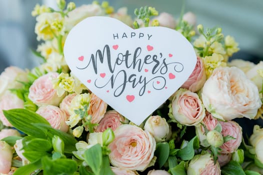 Amazing tender bouquet with pink ranunculus, violet Alstroemeria flowers and tiny white roses in cardboard box with pink ribbon. Beautiful bunch of spring flowers. Easter gift. Seasonal spring flowers