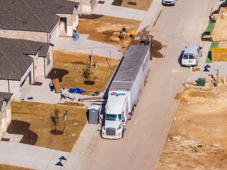Georgetown, TX - 25 February 2025: Moving truck unloading boxes into newly constructed home in Sun City