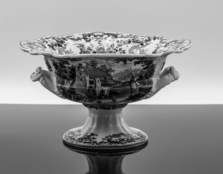 The exquisite porcelain bowl showcases a detailed landscape design, featuring handles shaped like animal heads.