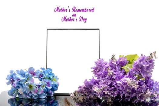 A simple yet elegant memorial display featuring a blank frame and beautiful lilac and blue flowers. Perfect for honoring cherished memories on Mother's Day, inviting reflection and love.